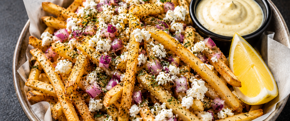 Greek Fries, cooked on a plate with feta, red onion and spices Greek Fries, cooked on a plate with feta, red onion and spices